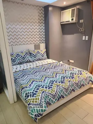 a bed with a colorful comforter in a room at Venice Luxury Residences in Manila