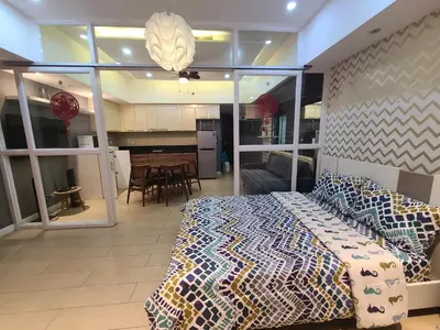 a bedroom with a bed and a living room at Venice Luxury Residences in Manila