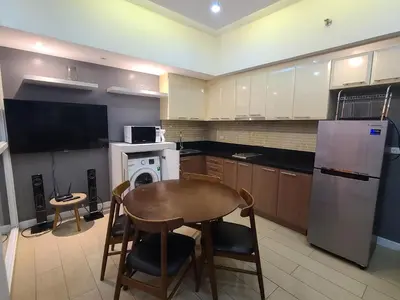a kitchen with a table and a refrigerator at Venice Luxury Residences in Manila