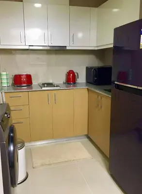 a kitchen with white cabinets and a red appliance at Daniella’s Modern & Cozy Suite in Uptown BGC in Manila