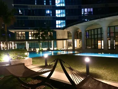 a hammock in front of a building at night at Daniella’s Modern & Cozy Suite in Uptown BGC in Manila