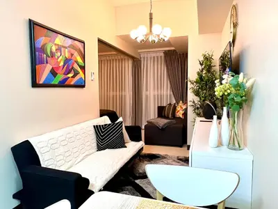 a living room with a couch and a table at Daniella’s Modern & Cozy Suite in Uptown BGC in Manila