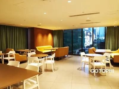a restaurant with tables and chairs and windows at The Knightsbridge Residences in Manila