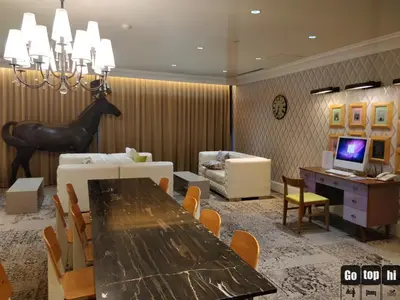 a dining room with a table and a living room with a desk at The Knightsbridge Residences in Manila