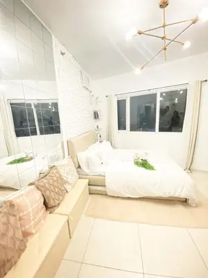 a white bedroom with a bed and a couch at Fully furnished condo in Quezon City in Manila