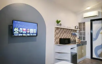 a kitchen with a flat screen tv on the wall at Hive Manila Guesthouse and Apartments 400 Mbps - Gallery Studio in Bacoor