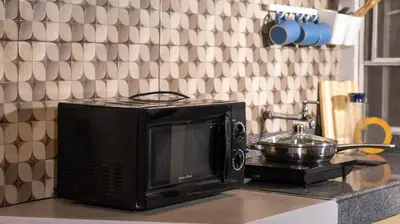 a microwave sitting on top of a kitchen counter at Hive Manila Guesthouse and Apartments 400 Mbps - Gallery Studio in Bacoor