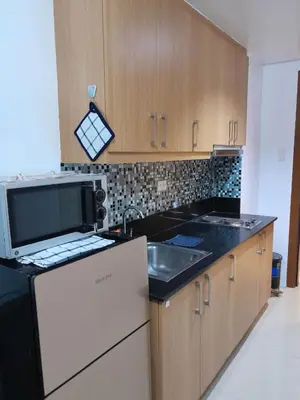 a kitchen with a sink and a microwave at Shell Residences C16 Shortwalk Sm Mall Of Asia/Airport in Manila