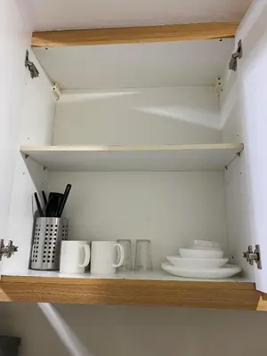 a shelf with cups and plates on it at Shell Residences C16 Shortwalk Sm Mall Of Asia/Airport in Manila