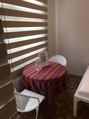 a table with a laptop on it with two chairs at Alta Vitas Daily in Manila