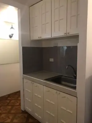 a kitchen with white cabinets and a sink at Alta Vitas Daily in Manila