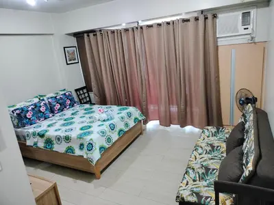 a bedroom with a bed and a couch at Room Across NAIA Terminal 3 at Newport in Manila