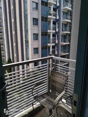 a balcony with a chair and a large building at Staycation Near Airport and resorts World Manila in Manila