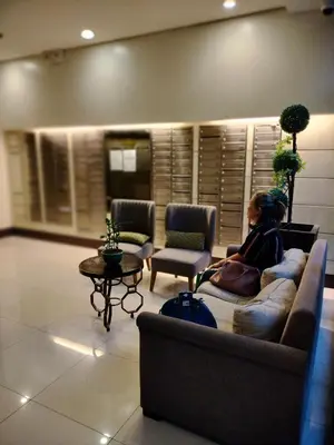 a woman sitting on a couch in a living room at Staycation Near Airport and resorts World Manila in Manila