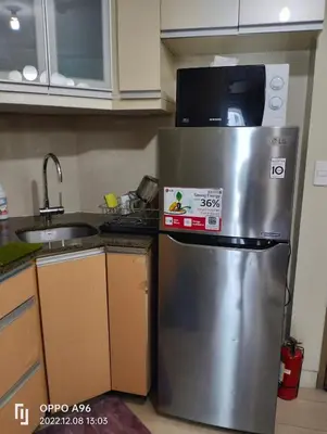 a kitchen with a stainless steel refrigerator with a microwave at Staycation Near Airport and resorts World Manila in Manila