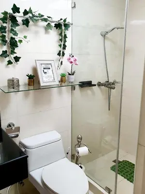 a bathroom with a toilet and a glass shower at McKinley Hill, BGC 3 Bedroom Unit Venice Mall Walking Distance in Manila