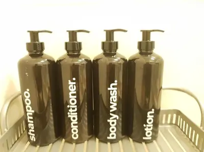 a group of four black plastic bottles sitting on a rack at McKinley Hill, BGC 3 Bedroom Unit Venice Mall Walking Distance in Manila