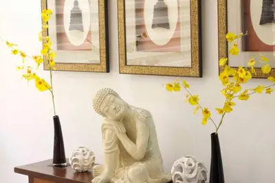 a white statue sitting on a table with flowers in vases at McKinley Hill, BGC 3 Bedroom Unit Venice Mall Walking Distance in Manila