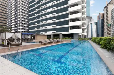a large swimming pool with chairs and a building at The Westin Manila in Manila