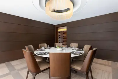 a dining room with a table and chairs and a chandelier at The Westin Manila in Manila