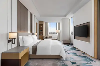 a hotel room with a bed and a flat screen tv at The Westin Manila in Manila