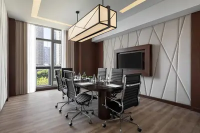 a conference room with a table and chairs and a television at The Westin Manila in Manila