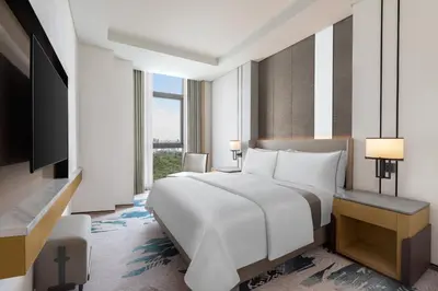 a bedroom with a large bed and a television at The Westin Manila in Manila
