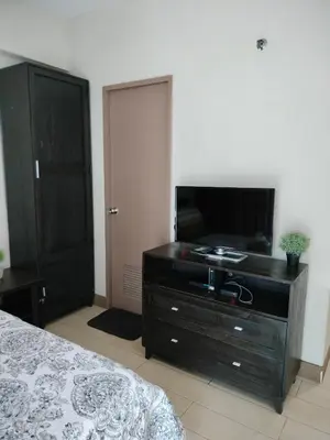 a bedroom with a bed and a dresser with a television at Condotel Pasay Newport Near Airport in Manila
