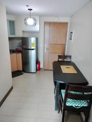 a kitchen with a table and a refrigerator at Condotel Pasay Newport Near Airport in Manila