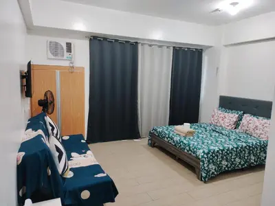a bedroom with a bed and a couch in it at Condotel Pasay Newport Near Airport in Manila