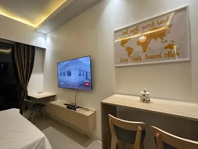 a hotel room with a bed and a tv on a wall at Homey Condo by the Bay in Manila