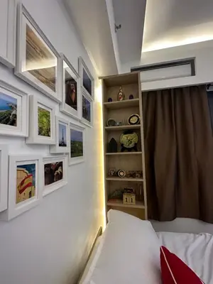 a bedroom with a bed and some pictures on the wall at Homey Condo by the Bay in Manila
