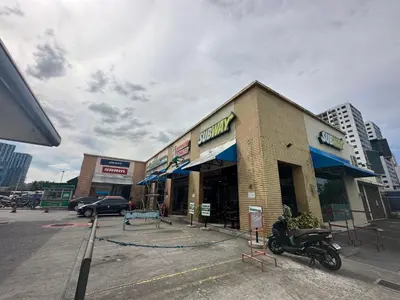 a store with a motorcycle parked in front of it at Homey Condo by the Bay in Manila