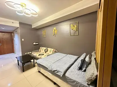 a bedroom with a bed and a table at Kathys crib 32sqm Condo Shell Residences in Manila