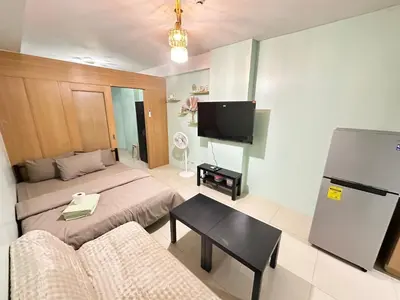 a living room with a bed and a couch and a tv at Kathys crib 32sqm Condo Shell Residences in Manila