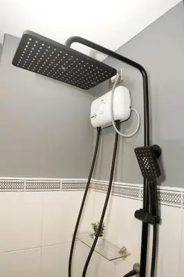 a shower with a white light on a wall at mySTAY Hotel BGC South in Manila
