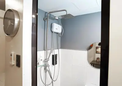 a shower in a bathroom with a blue wall at mySTAY Hotel BGC South in Manila
