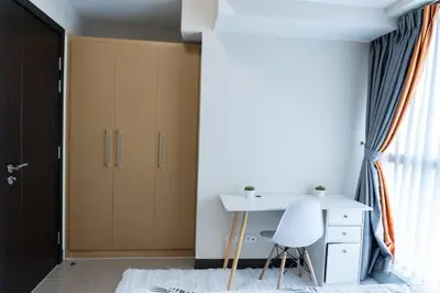 a room with a desk and a closet and a table at A2J Luxury 2BR BGC Uptown Suite Near Uptown Mall in Manila