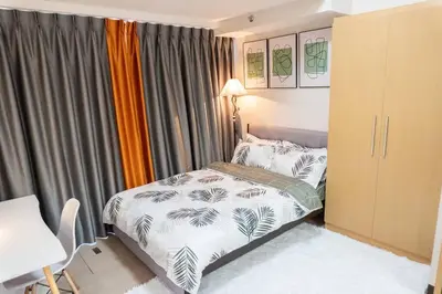 a small bedroom with a bed and a window at A2J Luxury 2BR BGC Uptown Suite Near Uptown Mall in Manila