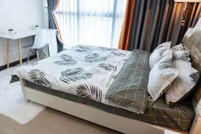 a bedroom with a bed with a desk and a window at A2J Luxury 2BR BGC Uptown Suite Near Uptown Mall in Manila