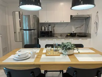 a kitchen with a wooden table with plates and dishes on it at San Lorenzo Place in Manila