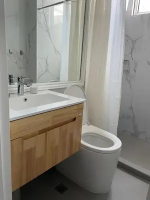 a bathroom with a toilet and a sink and a shower at San Lorenzo Place in Manila