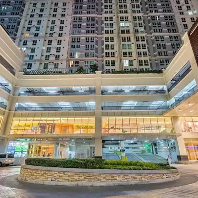a large building with tall buildings in the background at San Lorenzo Place in Manila