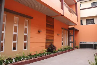 a facade of a building with orange at Anicia Guesthouse Rooms in Manila
