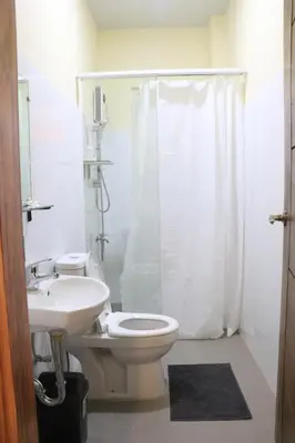 a bathroom with a toilet and a sink and a shower at Anicia Guesthouse Rooms in Manila