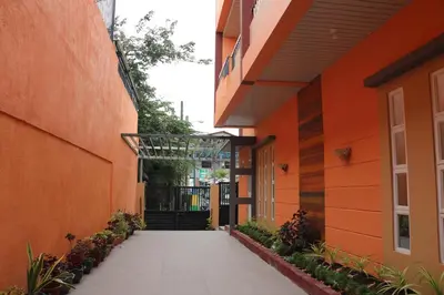 an orange building with a walkway between two buildings at Anicia Guesthouse Units in Manila