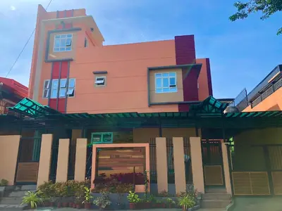 a pink building with a red at Anicia Guesthouse Units in Manila