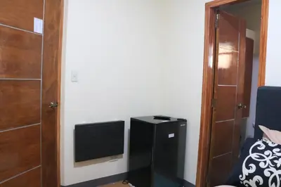 a small room with a television and a door at Anicia Guesthouse Units in Manila