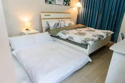 two beds in a small room with a bedskirts at A2J Luxury 3BR Uptown Balcony BGC Suite Near Mall in Manila