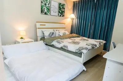 two beds in a small room with blue curtains at A2J Luxury 3BR Uptown Balcony BGC Suite Near Mall in Manila